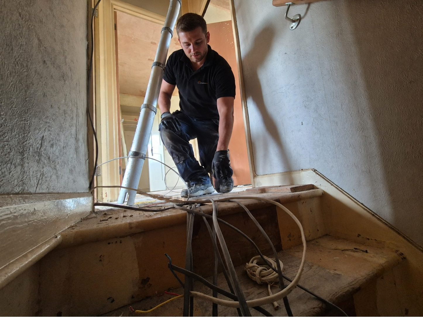 Electrician feeding cable through a stairwell